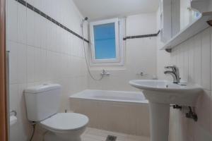 a white bathroom with a toilet and a sink at Melanthi urban in Volos +11 photos
