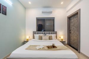 a bedroom with a large white bed with two animals on it at Alaya Stays with Balcony & Hill View - Lake City Heights in Udaipur