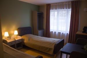 a hotel room with a bed and a window at Mõisa Ait Stuudiokorterid in Võru +9 photos