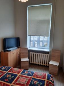 una camera da letto con un letto, una tv e una finestra di Spacy apartment in Kaunas center a Kaunas