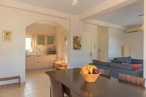 a living room with a table and a blue couch at Villa Petra in Karavados in Karavadhos +109 photos