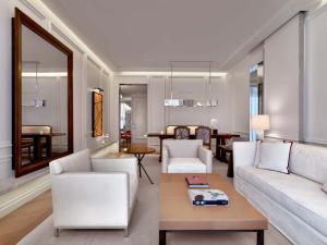 a living room with white furniture and a table at Baccarat Hotel and Residences New York in New York