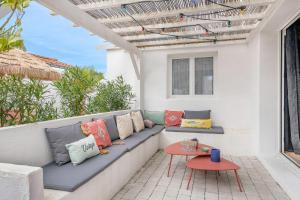 eine Terrasse mit einer Couch und einem Tisch in der Unterkunft À 400m de la plage, maison renovée pour 6 in Préfailles
