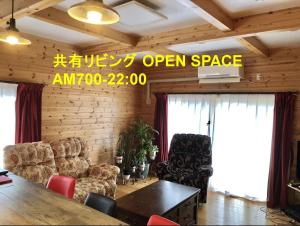 八户市津軽三味線と民謡 ゲストハウス繭子の宿的客厅配有桌子和两把椅子 更多41张照片