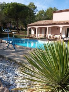 a swimming pool in front of a house at Le Mas Victoria - Chambres d'hôtes avec table d'hôtes-Parking privé ferme in Carcassonne