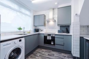 a kitchen with a washer and a washing machine at NEW! 3-Bed Home in Manchester by 53 Degrees Property, Ideal for Contractors & Business Stays, Sleeps 8! in Manchester