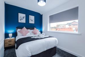 a bedroom with a bed with blue walls and a window at NEW! 3-Bed Home in Manchester by 53 Degrees Property, Ideal for Contractors & Business Stays, Sleeps 8! in Manchester