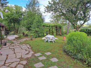 ÉguillyにあるLa Maison des Renouillersの白いテーブルと椅子が置かれた庭園 +12枚の写真
