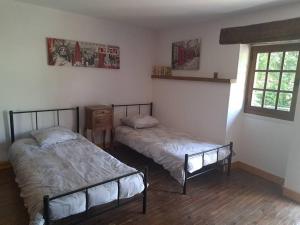 ÉguillyにあるLa Maison des Renouillersのベッド2台と窓のある寝室