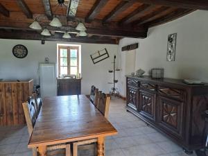 ÉguillyにあるLa Maison des Renouillersの木製のテーブルとキッチンのあるダイニングルーム