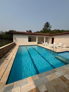 a swimming pool with chairs and a house at Chácara A Grande Família in Sao Paulo