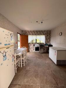 a kitchen with a refrigerator and a table in it at Chácara A Grande Família in Sao Paulo