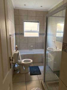 a bathroom with a toilet and a tub and a sink at 16 on Swallow in East London