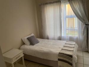 a small bedroom with a bed and a window at 16 on Swallow in East London