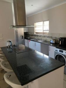 a kitchen with a black counter top with a dishwasher at 16 on Swallow in East London