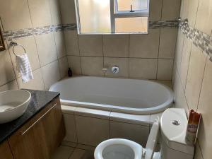 a bathroom with a tub and a toilet and a sink at 16 on Swallow in East London