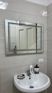 a bathroom with a sink and a mirror at Todhe Apartment - Gjiri Lalezit 500m from the beach in Draç +35 photos