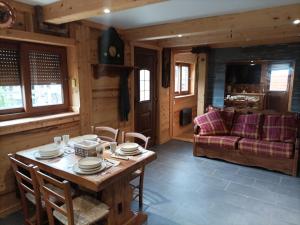 a living room with a wooden table and a couch at Joli Appart Terrasse et jardinet in Albertville