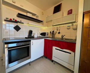 een keuken met een fornuis en een rode aanrecht bij Résidence Grand Bois A310 Clés Blanches in La Tania
