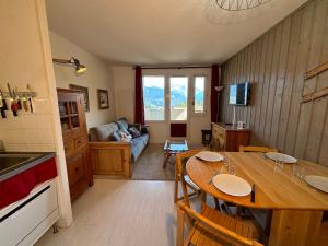 een keuken en woonkamer met een tafel en een bank bij Résidence Grand Bois A310 Clés Blanches in La Tania