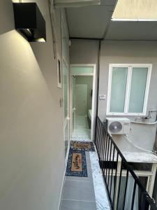 a hallway with a staircase with a window and a rug at Valentino caracciolo 105 in Naples