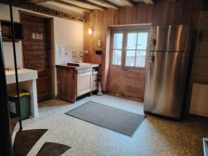 a kitchen with a stainless steel refrigerator and a door at La Belle Étoile in La Chartre-sur-le-Loir +10 photos