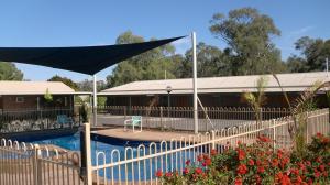 
a patio area with an umbrella and a fence at Tooleybuc Motel in Tooleybuc
