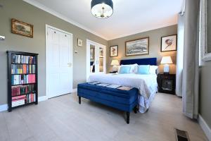 a bedroom with a large bed and a blue ottoman at En-suite luxury large bedroom with parking and two tickets to Kew Gardens in Kew Gardens +11 photos
