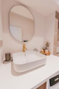 een badkamer met een witte wastafel en een spiegel bij Chic T2 climatisé proche plages in Châteauneuf-lès-Martigues +3 foto's