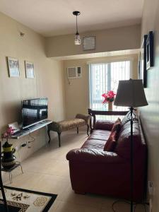 a living room with a couch and a television at Belle's Staycation in Cebu City