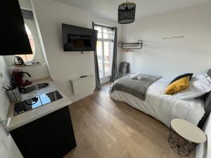 リエヴァンにあるVue sur les Toits - 2p Centre-villeのベッドと洗面台のある小さな寝室