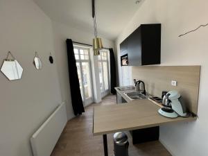 a kitchen with a sink and a counter top at Sous les Toits - 2p Centre-ville in Liévin