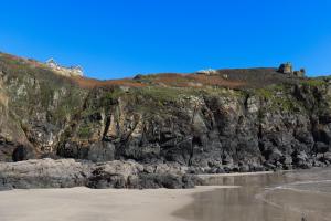 a house on top of a cliff next to a beach at Housel Bay Hotel in Lizard
