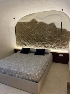 un letto in una stanza con un muro di pietra di Domus Parthenope Deluxe a Napoli