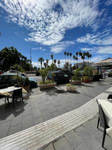 un parcheggio con tavoli, sedie e palme di Domus Parthenope Deluxe a Napoli