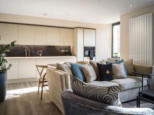 a living room with a couch and a kitchen at Arran Shores Luxury Shorefront Apartment 4 in Lamlash +13 photos