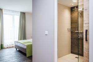 ein Schlafzimmer mit einem Bett und einer Dusche in der Unterkunft Gasthaus Forster am See - Eching bei Landshut in Eching