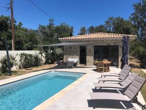 a pool with chairs and a table and a house at Villa Ucellu sur 600 m2 avec accès mer privilégié et piscine privée chauffée in Sainte-Lucie de Porto-Vecchio