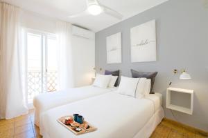 een witte slaapkamer met een wit bed en een dienblad met eten erop bij My City Home - Acogedor apartamento en Aravaca in Madrid
