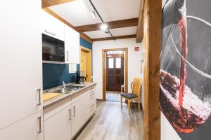 a kitchen with white cabinets and a football painting on the wall at Hotel Stadt Lüdenscheid, Domizil Herzogstraße in Lüdenscheid