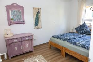 a bedroom with a bed and a dresser and a mirror at Ländliches Apartment Sonnenblume in Polch