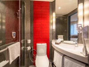 a bathroom with a sink and a red wall at Ibis Saigon Airport in Ho Chi Minh City