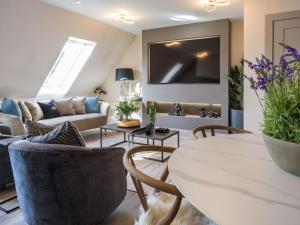 a living room with a couch and a table at Arran Shores Luxury Shorefront Apartment 14 in Lamlash