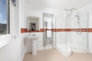 a white bathroom with a sink and a shower at Waterfront House in Saint Clement +37 photos