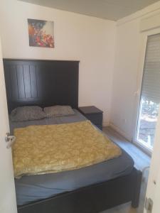 een slaapkamer met een bed met een houten hoofdeinde en een raam bij Bungalow en finca de campo in Islas Baleares