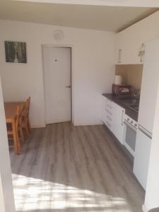 een keuken met witte muren, een tafel en een deur bij Bungalow en finca de campo in Islas Baleares