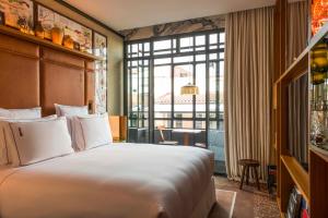 マドリードにあるBrach Madrid - Evok Collectionのベッドと大きな窓があるホテルの部屋 +41枚の写真