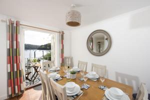 a dining room with a table and chairs and a mirror at Waterfront House in Saint Clement