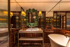 a bathroom with a tub and a sink and a mirror at Brach Madrid - Evok Collection in Madrid