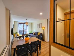 a room with a table and chairs and a living room at Apartamentos Escarrilla Suites 3000 in Escarrilla